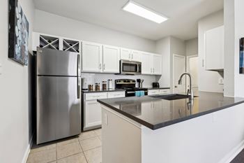 A kitchen with a stainless steel refrigerator